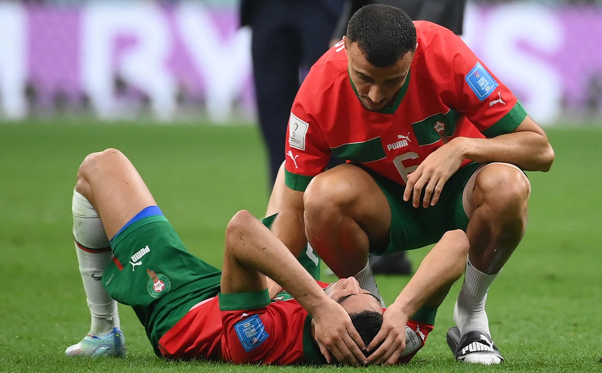 Morocco's defender #06 Romain Ghanem Saiss comforts Morocco's defender #02 Achraf Hakimi at the end of the Qatar 2022 World Cup semi-final football match between France and Morocco at the Al-Bayt Stadium in Al Khor, north of Doha on December 14, 2022. (AFP)