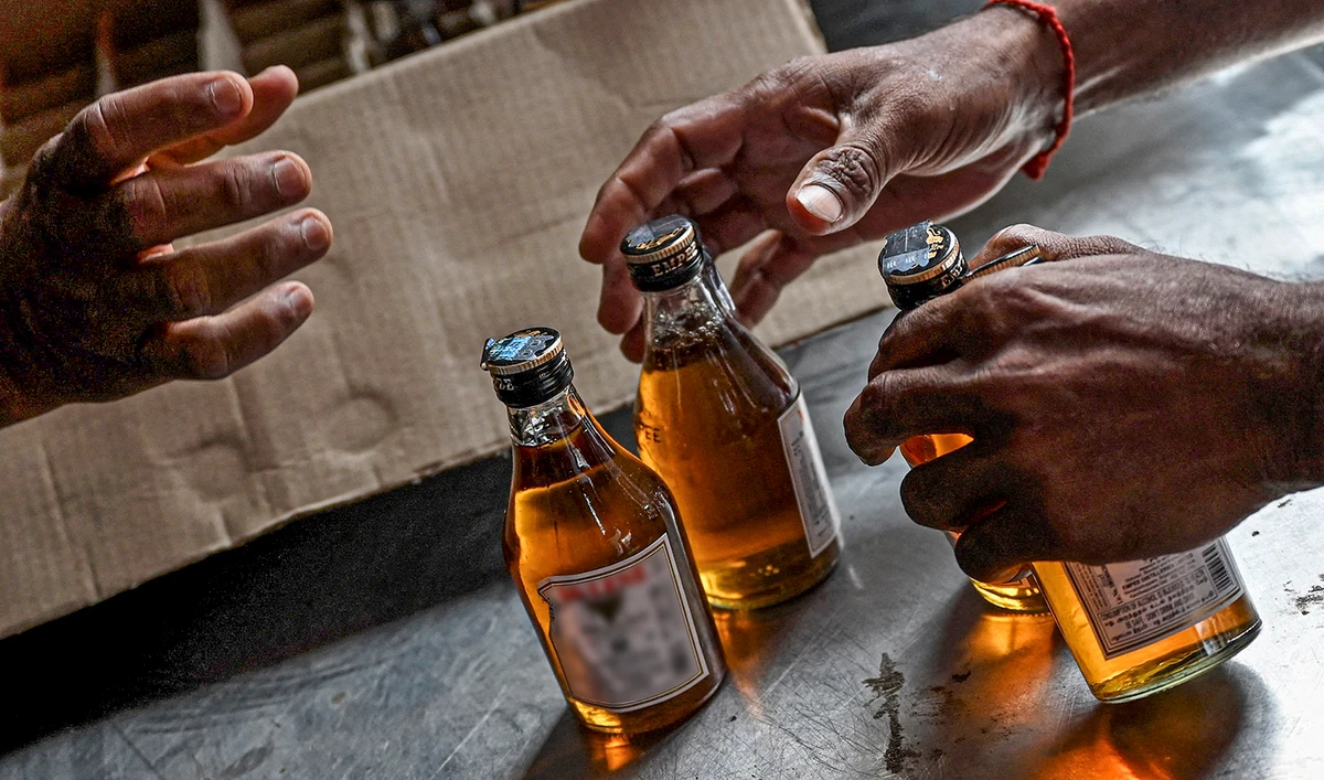 This representational photo shows a customer purchasing liquor from the counter at a liquor store in India on June 14, 2021. (AFP/File)