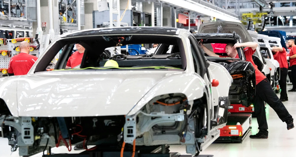 Porsche employees work on Porsche Taycan electric sports cars at the assembly line in Stuttgart, southwestern Germany. EU leaders are resisting the US’ new green technologies plan. (AFP)