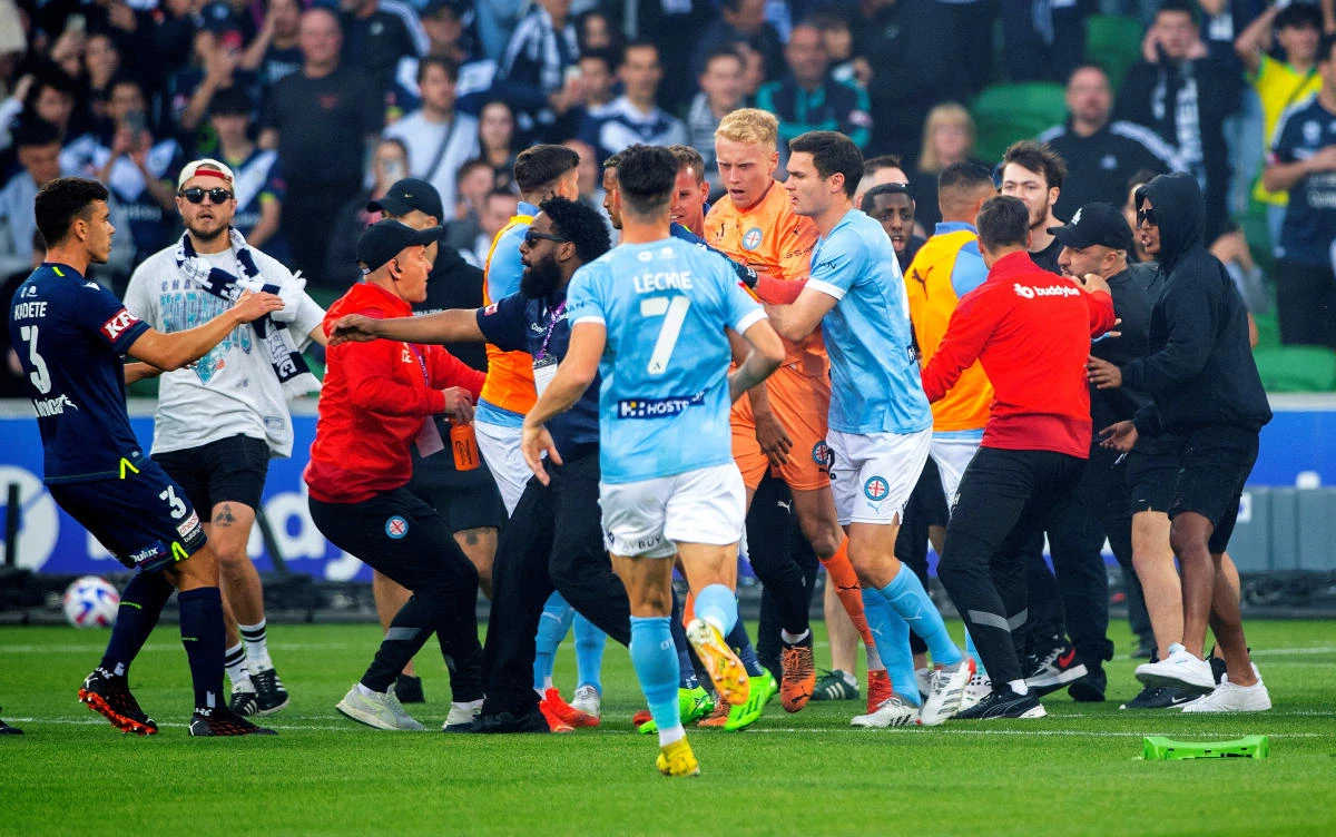 Goalkeeper injured as fans invade pitch in Melbourne derby