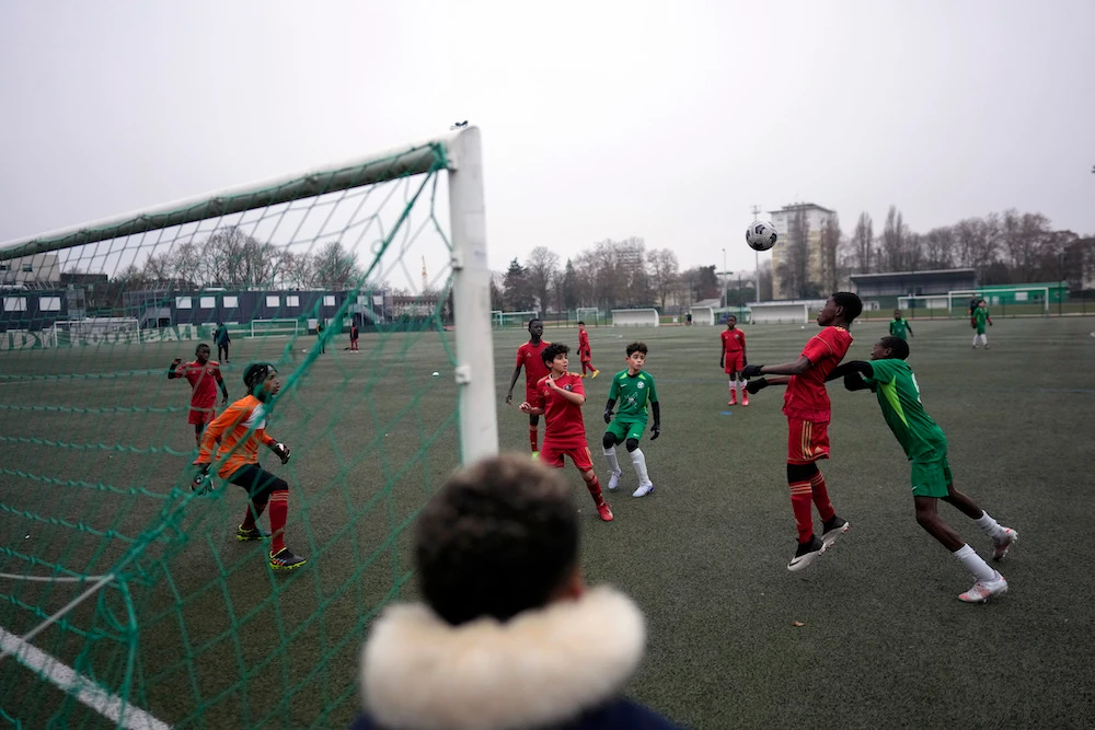 A boy watches players of the football club AS Bondy, where Kylian Mbappe played as a kid, in green, during a match on the Leo Lagrange stadium in Bondy, east of Paris, Saturday. (AP)