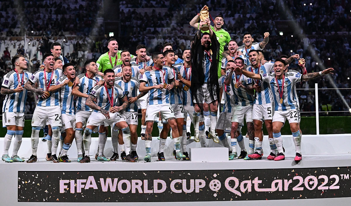 Argentina's forward #10 Lionel Messi (C) holds up the FIFA World Cup Trophy as he celebrates with teammates winning the Qatar 2022 World Cup final football match between Argentina and France at Lusail Stadium in Lusail, north of Doha on December 18, 2022. (Photo courtesy: AFP)
