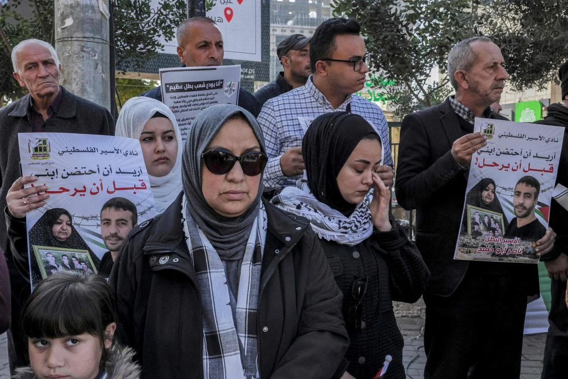 People gather for a protest against the death of Palestinian prisoner Nasser Abu Hamed in Israeli prison in city centre of the flashpoint city of Hebron in the occupied West Bank. (AFP)