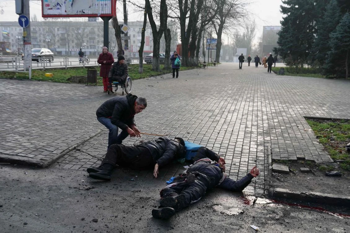 A man examines laying bodies of civilian people after Russian shelling. (AFP)