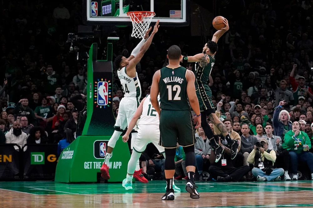 Boston Celtics forward Jayson Tatum drives in for the slam dunk over Milwaukee Bucks forward Giannis Antetokounmpo during the first half of an NBA basketball game Sunday, in Boston. (AP)