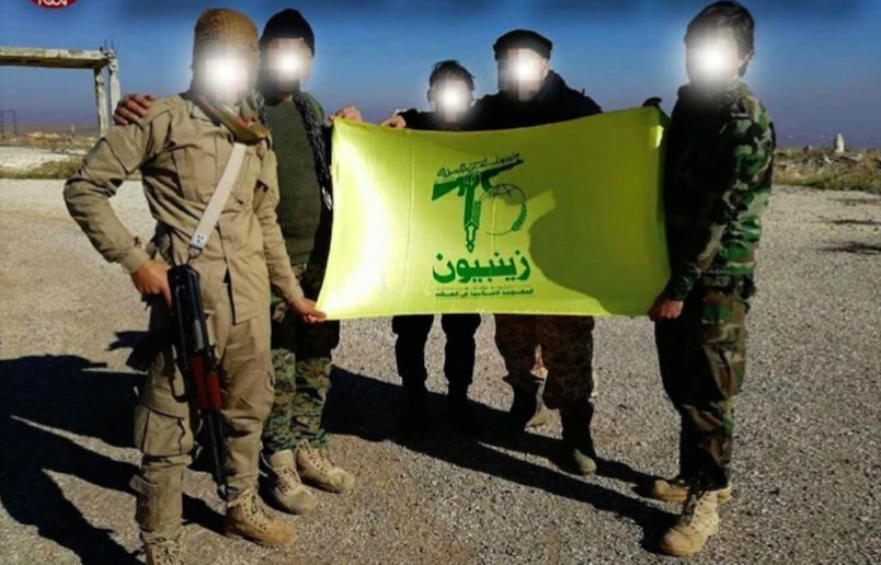 This undated photo taken in Syria shows Pakistani fighters from the Iran-backed Zainabiyoun Brigade holding the militant group’s flag. (Social media)