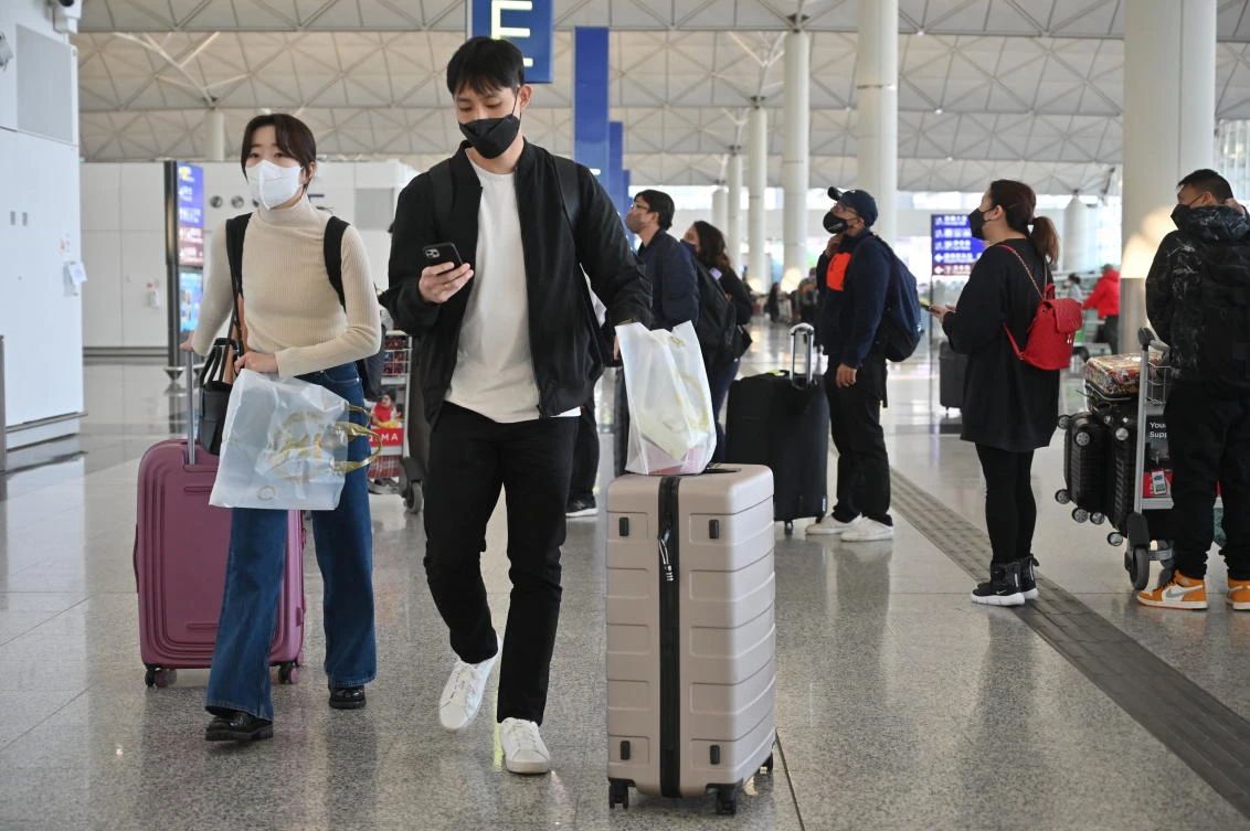 Passengers head to check-in counters at the international airport in Hong Kong on December 28, 2022. (File/AFP)