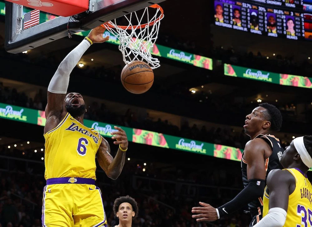 LeBron James of the Los Angeles Lakers dunks against Onyeka Okongwu of the Atlanta Hawks during the fourth quarter of their NBA game at State Farm Arena on Friday in Atlanta, Georgia.(AFP)