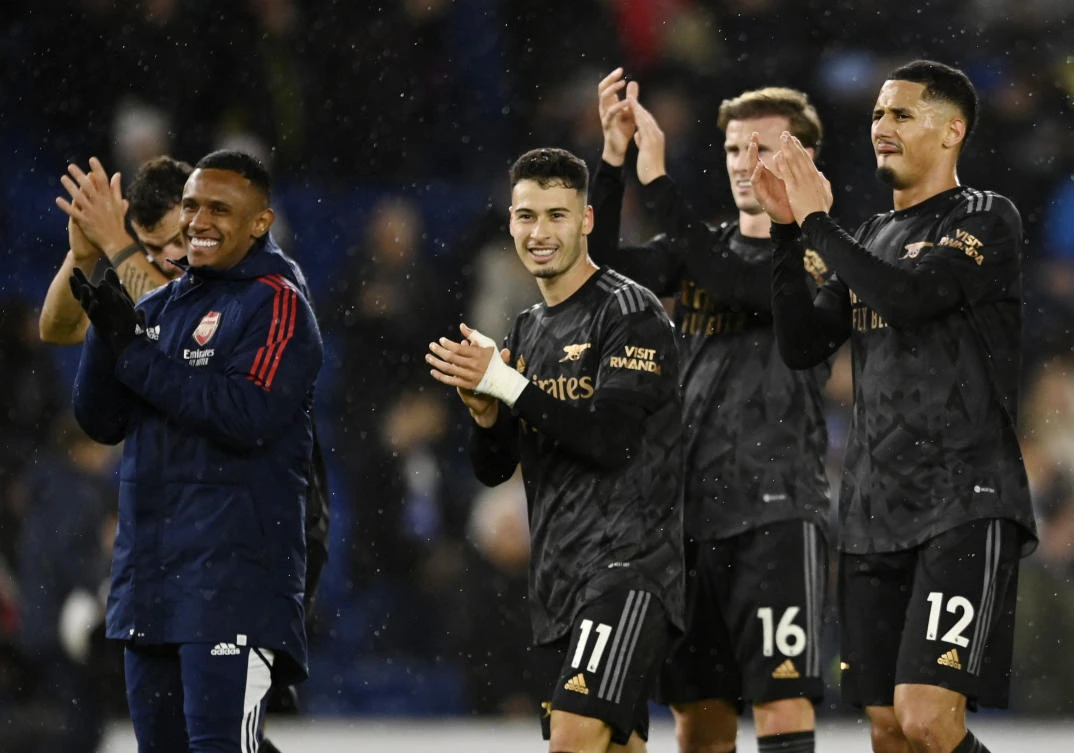 Arsenal’s Gabriel Martinelli, Rob Holding and William Saliba celebrate after the match with Brighton & Hove Albion. (Reuters)