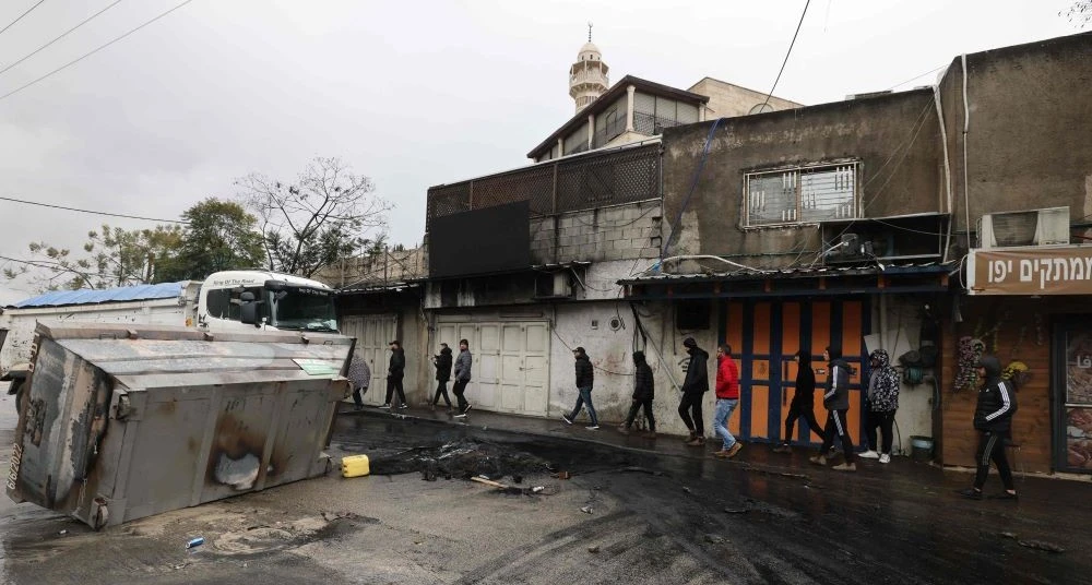 Palestinian men walk past closed shops during a strike against house demotions, Jabal Mukaber, Jerusalem, Jan. 31, 2023. (AFP)