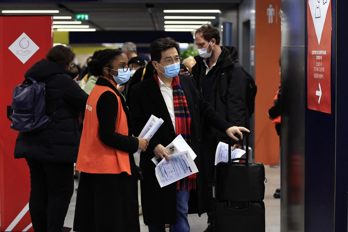 Passengers arriving from China wait in front of a COVID-19 testing area set at the Roissy Charles de Gaulle airport on Jan. 1, 2023. (AP)