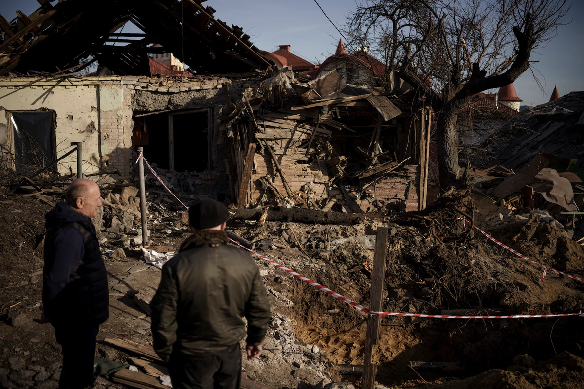 People stand next to the site of a Russian attack in Kyiv, Ukraine, Monday, Jan. 2, 2023. (AP)