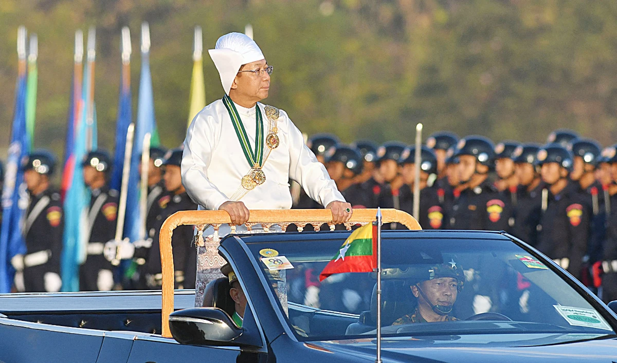 Myanmar’s military chief Min Aung Hlaing stands in a car as he oversees a military display at a parade ground to mark the country’s Independence Day in Naypyidaw on Wednesday. (AFP)