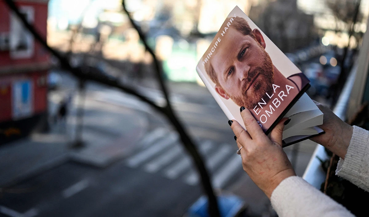 A woman leafs through the "En la sombra" (In the shadow) Spanish version of the book "Spare" an autbiography by Britain's Prince Harry after buying it in Madrid on January 5, 2023. (AFP)