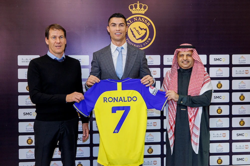 Saudi Arabia's al-Nassr football club shows Portugal's forward Cristiano Ronaldo posing with the club's number seven jersey alongside Al-Nassr's French coach Rudi Garcia (L) and club president Musalli Al-Muammar during a press conference at the Mrsool Park Stadium in the Saudi capital Riyadh (AFP)