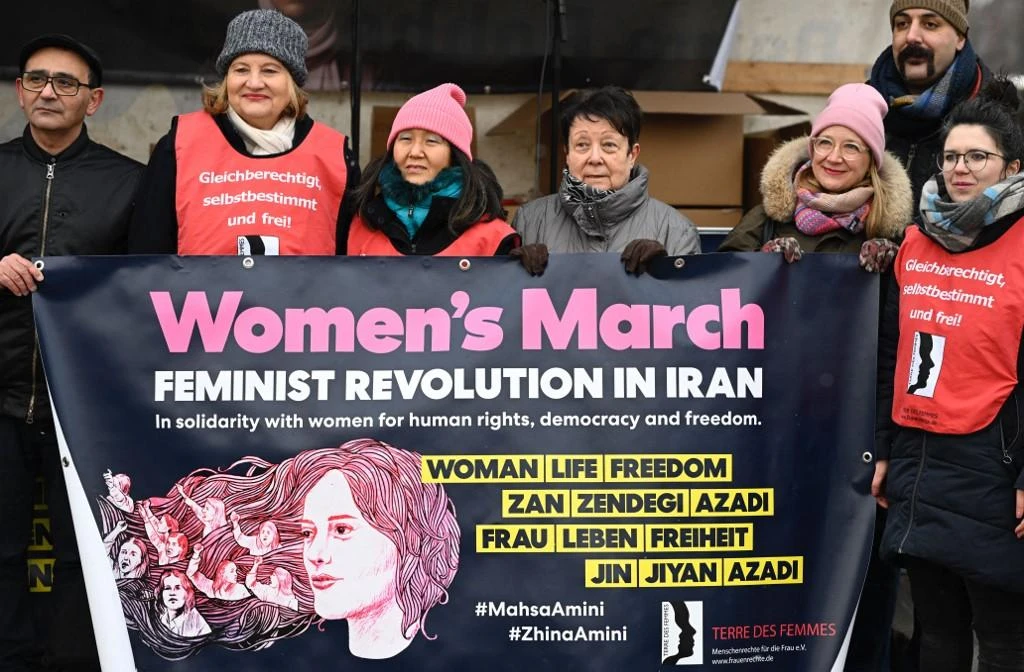 Protesters hold a banner reading “Feminist revolution in Iran” during a women’s march in solidarity with demonstrators in Iran in Berlin. (File/AFP)