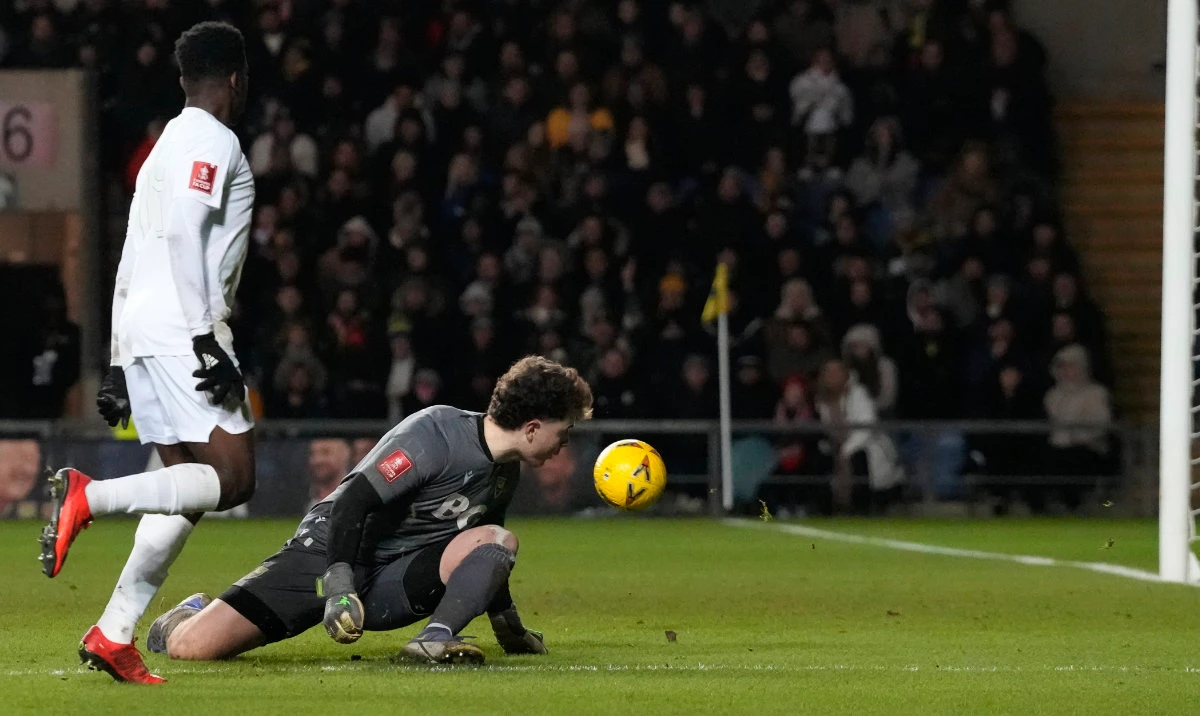 Arsenal's Eddie Nketiah, left, scores his side's third goal past Oxford goalkeeper Edward McGinty during their English FA Cup soccer match at the Kassam Stadium in Oxford Monday. (AP)