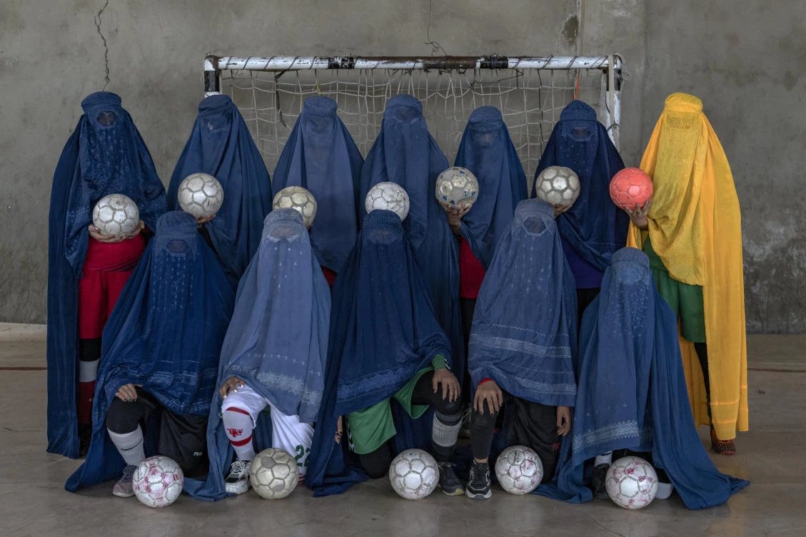 A number of Afghani women pose for portraits with the equipment of the sports they loved. They chose to hide their identities with their burqas because they fear Taliban (AP)