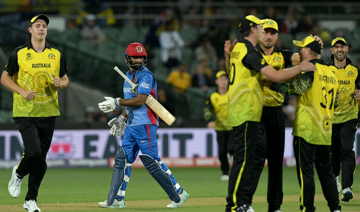Afghanistan's Usman Ghani (C) departs as Australian players celebrate his dismissal during the ICC men's Twenty20 World Cup 2022 cricket match between England and New Zealand at The Gabba on November 1, 2022 in Brisbane. (AFP)