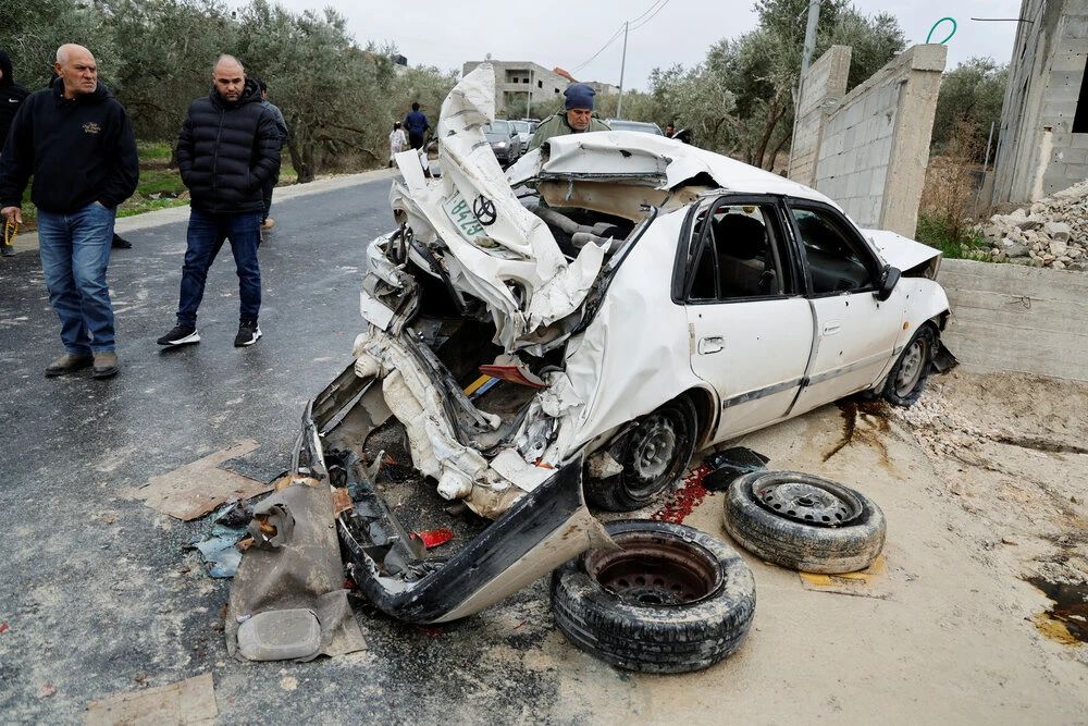 People check a damaged car where two Palestinian militants were killed during an Israeli operation, near Jenin, in the Israeli-occupied West Bank, January 14, 2023. (Reuters)