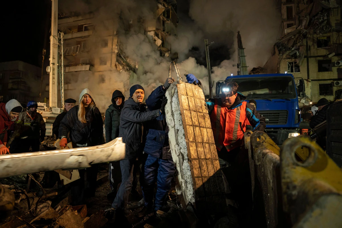 Residents clear the rubble after a Russian rocket hit a multistory building leaving many people under debris in the southeastern city of Dnipro, Ukraine, on Jan. 14, 2023. (AP)