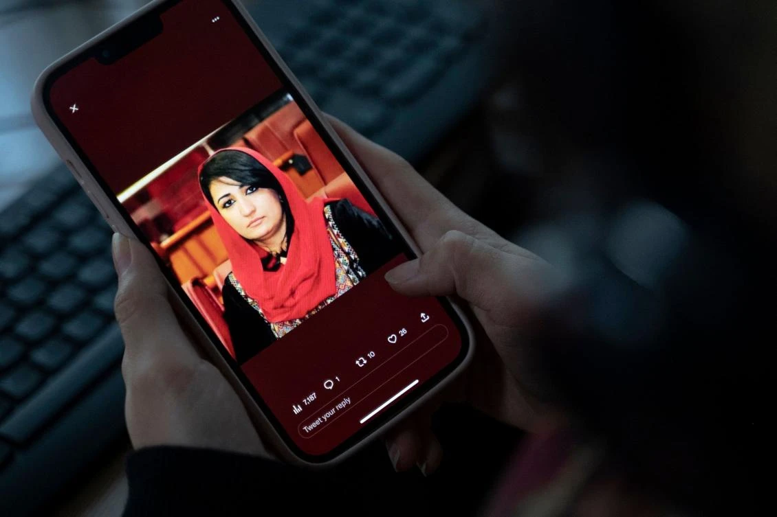 A woman looks at a picture of former Afghan lawmaker Mursal Nabizada on her mobile phone, who was shot dead by gunmen last night at her house in Kabul on January 15, 2023. (AFP)