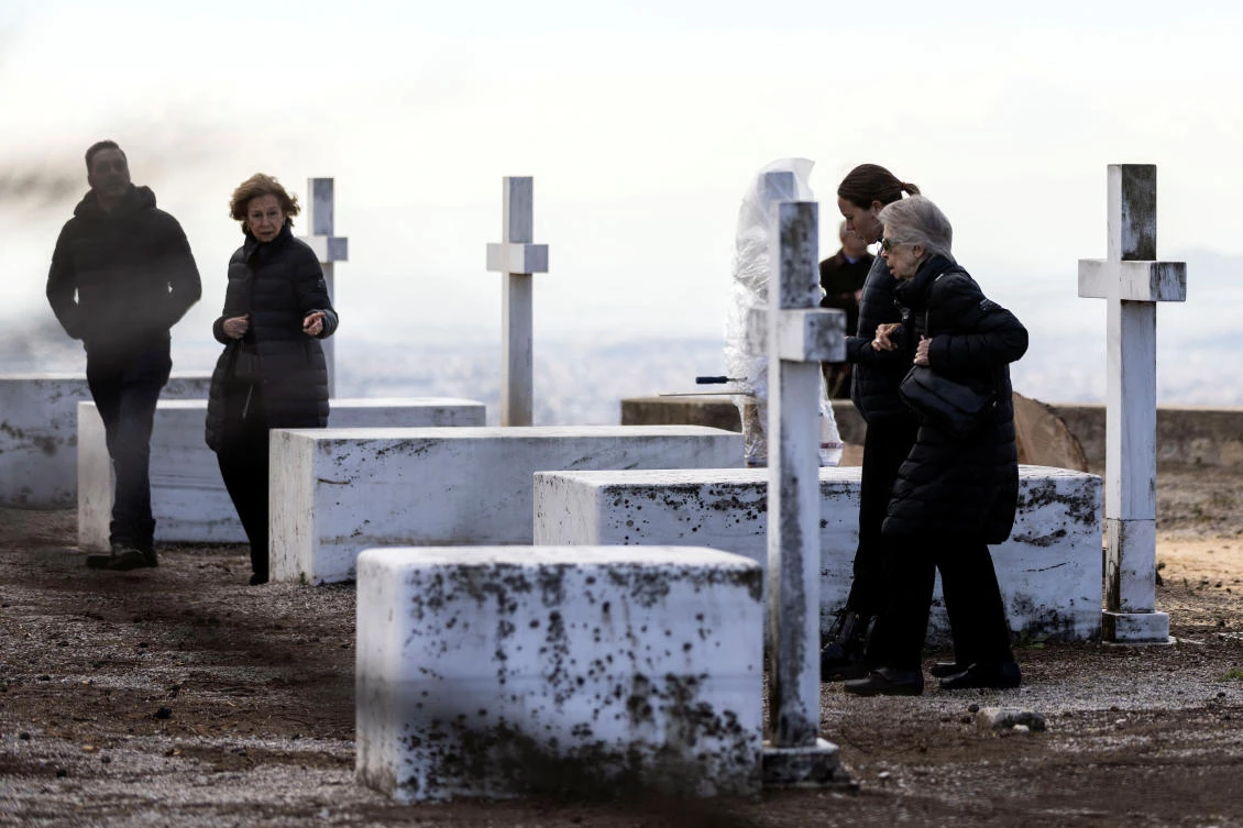 Spain's former queen Sofia and Greece's former princess Irene, sisters of Greece's late former King Constantine II, walk among tombs of members of the former Greek royal family. (Reuters)