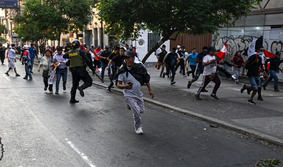 People clash with the police while protesting against the government of Peruvian President Dina Boluarte in Lima on January 17, 2023. (AFP)