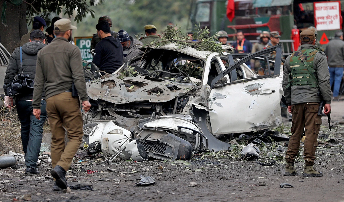 Indian security force personnel stand guard next to a damaged vehicle after a bomb blast in Narwal area of Jammu on January 21, 2023. (REUTERS)