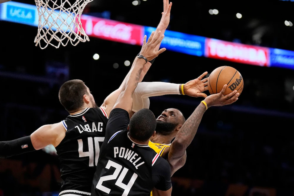 Los Angeles Lakers forward LeBron James, right, shoots as Los Angeles Clippers center Ivica Zubac, left, and forward Norman Powell defend during the second half of an NBA basketball game Tuesday in Los Angeles. (AP)