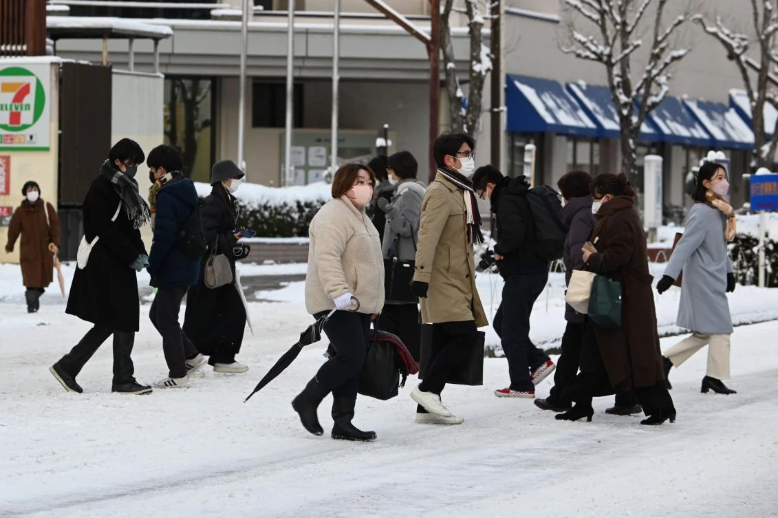 People walk on a snow-covered road in Nagano on January 25, 2023. (AFP)