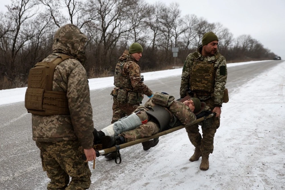Medics of Ukrainian Army evacuate a wounded soldier on a road not far of Soledar, Donetsk region (AFP)