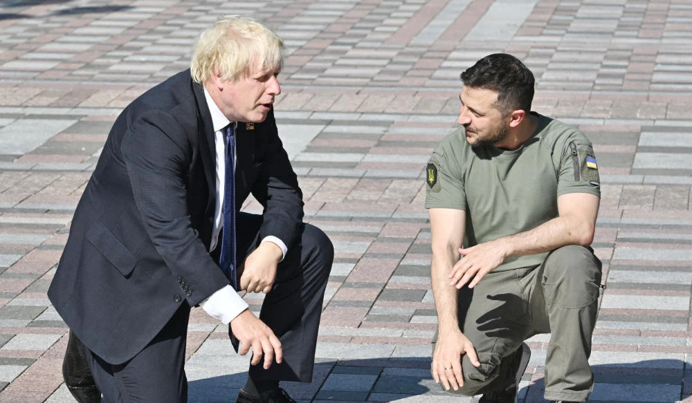 Ukrainian President Volodymyr Zelensky (R) shows British Prime Minister Boris Johnson (L) his name engraved on a plaque inaugurated at the Ally of Bravery on Ukraine's Independence Day on August 24, 2022, amid Russia's invasion of Ukraine. (AFP)