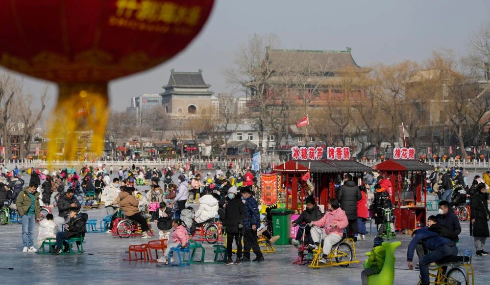 Visitors enjoy skating on the crowded frozen Houhai Lake near the Drum Tower, background, in Beijing, Monday, Jan. 30, 2023. (AP)