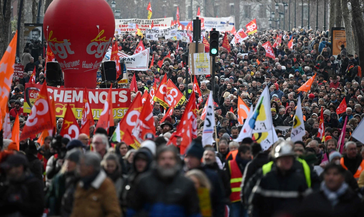 Protesters hold CGT union flags during a rally on a second day of nationwide strikes and protests over the government's proposed pension reform, in Toulouse on January 31, 2023. (AFP)