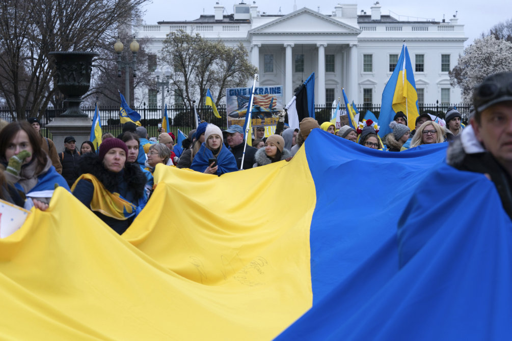 Demonstrators hold a Ukrainian flag as they march outside of the White House in support of Ukraine during a rally. (AP)