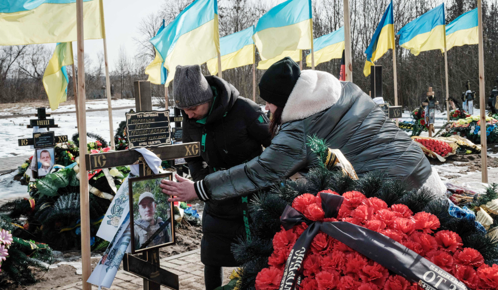 The wife (R) and sister of a Ukrainian serviceman died on January 17 visit his grave at a cemetery in Kramatorsk. (AFP)