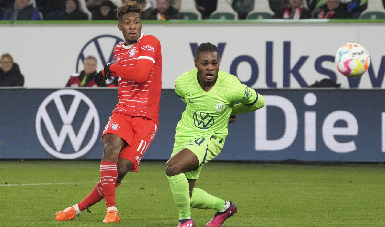 Bayern's Kingsley Coman, left, scores his side's second goal as Wolfsburg's Ridle Baku fails to block the shot during their German Bundesliga soccer match in Wolfsburg Sunday. (AP)