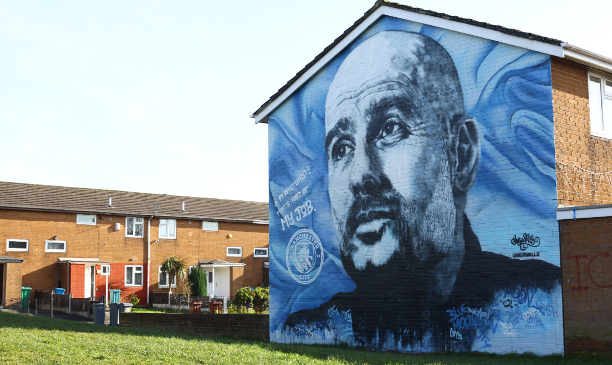 A mural of Manchester City manager Pep Guardiola is seen after Manchester City were charged with breaking financial rules by the Premier League at Etihad Stadium, Manchester on Monday. (Reuters)