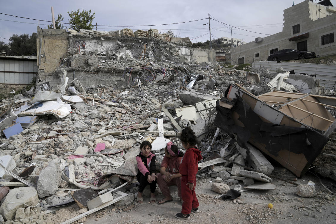 Girls from the Matar family sit near the rubble of their home that housed 11 people before it was demolished by Israeli authorities in the Jabal Mukaber neighborhood of east Jerusalem (AP)