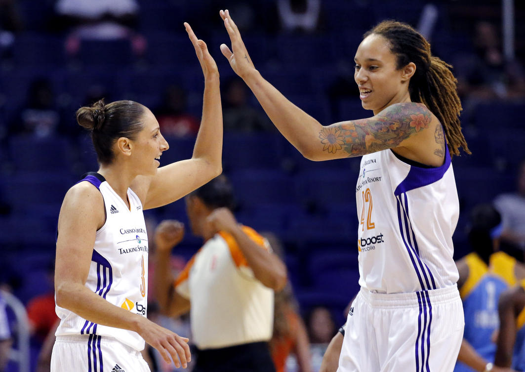 Phoenix Mercury guard Diana Taurasi, left, high-fives teammate Brittney Griner during the first half of a WNBA basketball game against the Chicago Sky, on July 2, 2014, in Phoenix. (AP/File)