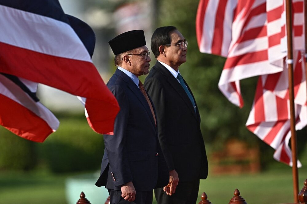 Malaysia’s Prime Minister Anwar Ibrahim, left, and Thailand’s Prime Minister Prayuth Chan-ocha listen to their national anthems during a welcoming ceremony at the Government House in Bangkok, Thailand, Thursday, Feb. 9, 2023. (AFP)