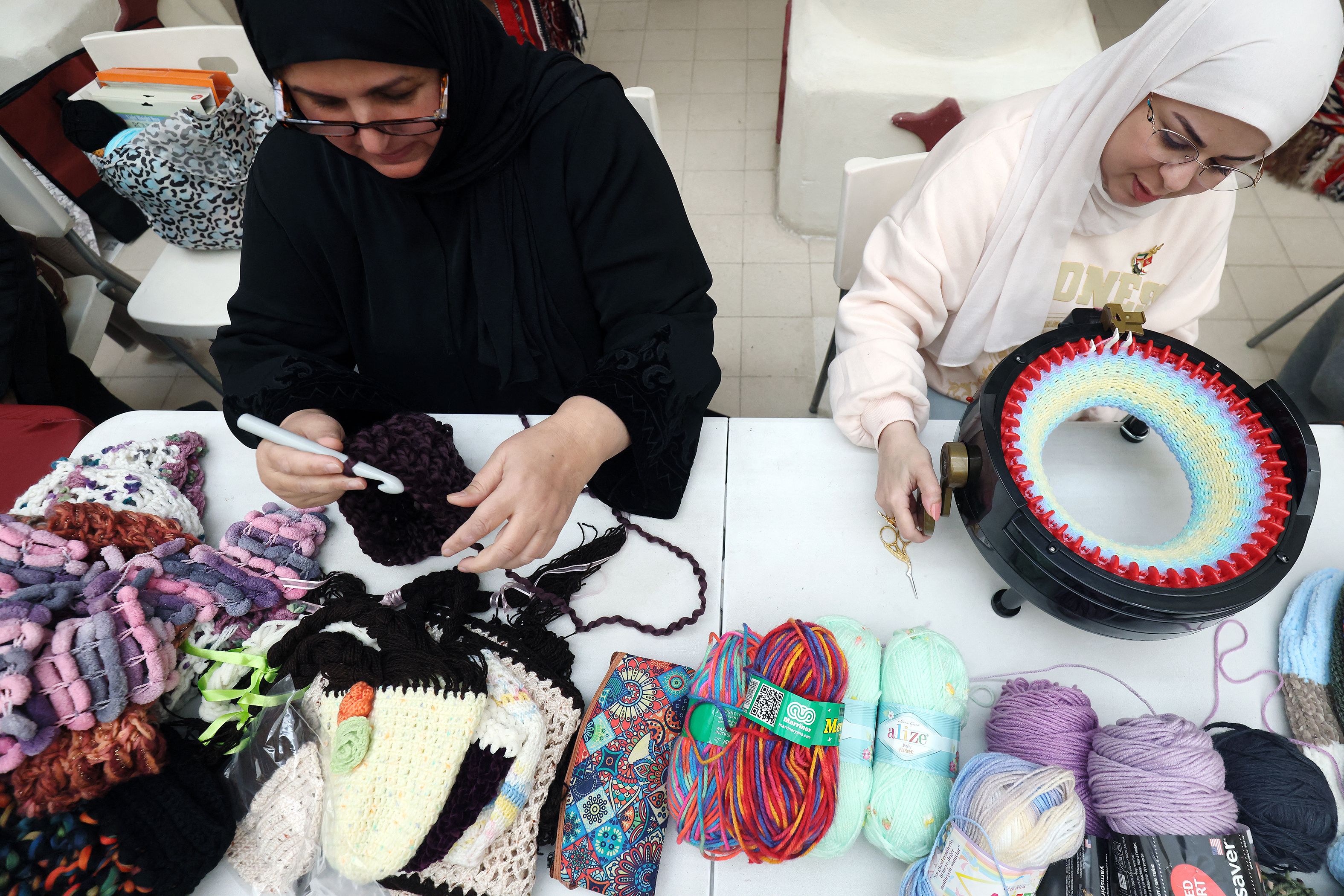 Kuwaiti women produce warm scarves and hats in Kuwait City on Feb. 11, 2023 to be sent to those affected by the deadly earthquake that hit Turkiye and Syria. (AFP)