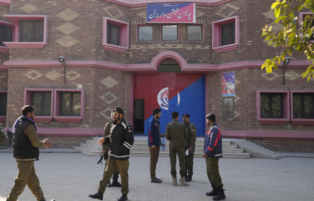 Police officers gather outside a police station, in Warburton, an area of district Nankana, Pakistan, Sunday, Feb. 12, 2023. (AP)