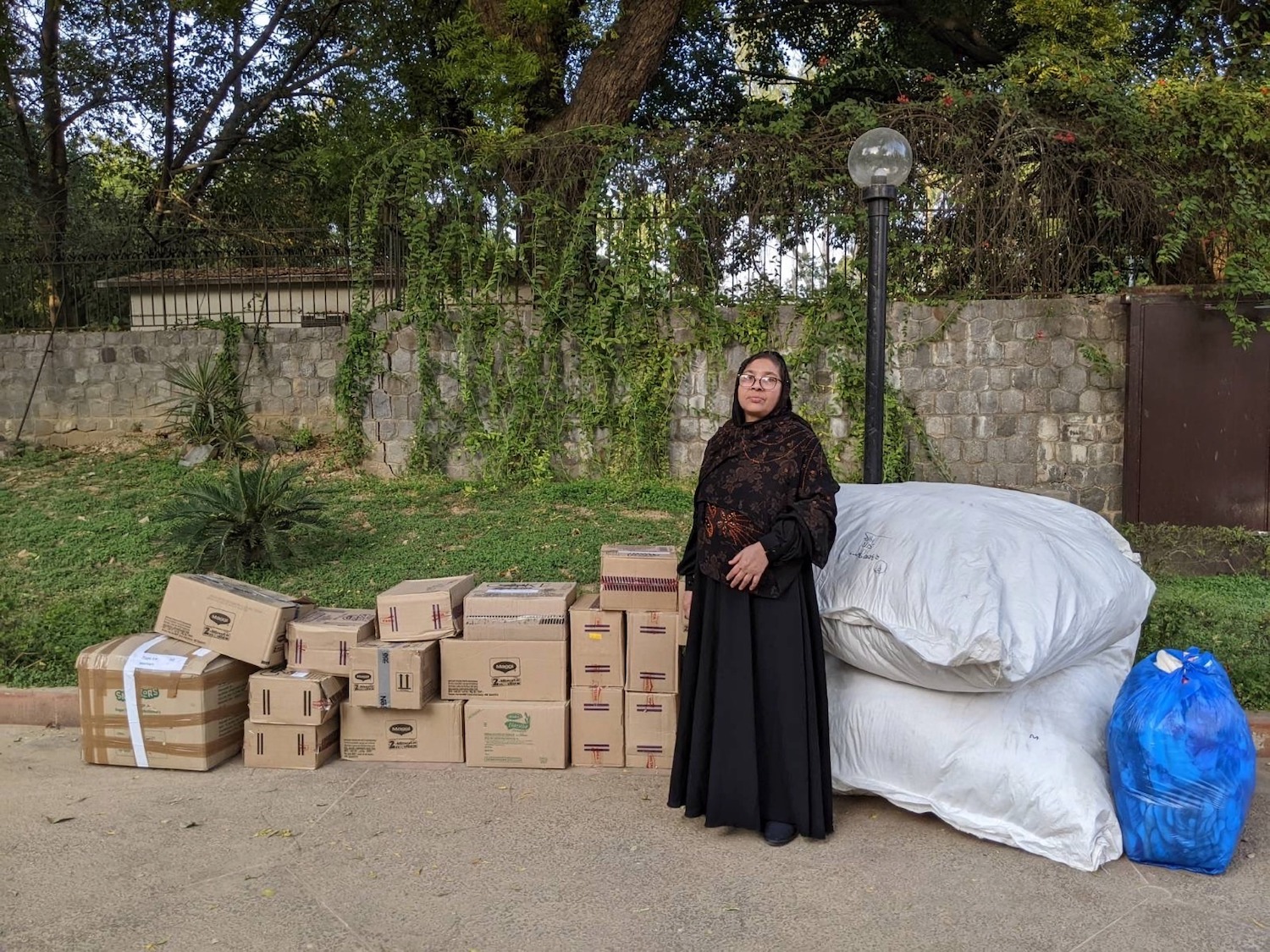 Amina Khatoon, a 56-year-old Rohingya refugee in India, poses for a photo on Feb. 11, 2022 with donations she purchased to help survivors of the Turkiye - Syria earthquake. (Ali Jouhar)