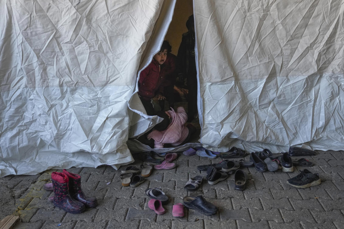 A Syrian child looks on from inside a tent used as a shelter in a public market space in Islahiye District of Gaziantep, southern Turkey, Saturday, Feb. 11, 2023. (AP)