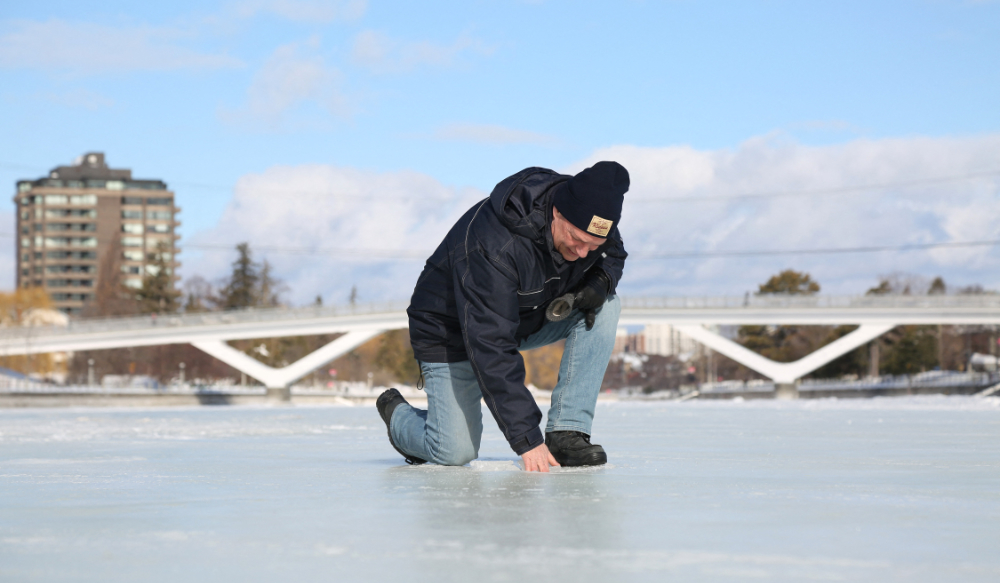 Bruce Devine, senior manager facilities and programs at the National Capital Commission checks the ice condition on the Rideau Canal on February 8, 2023 in Ottawa, Canada. (AFP)