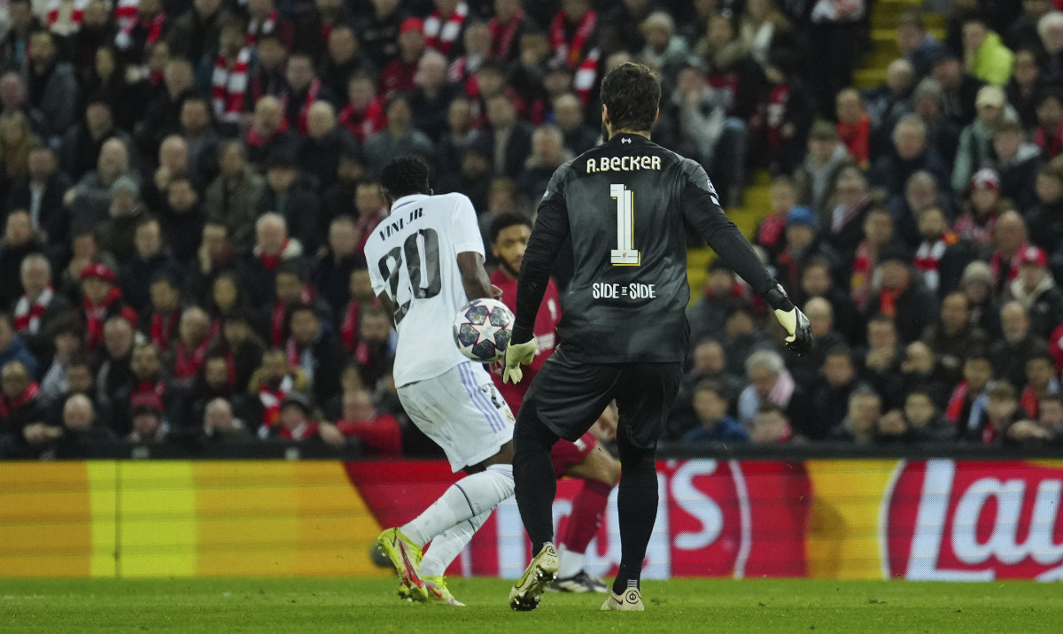 Real Madrid's Vinicius Junior, left, scores their side's second goal in front Liverpool's goalkeeper Alisson Becker during the Champions League round of 16 first leg match against Liverpool at the Anfield stadium Tuesday. (AP)