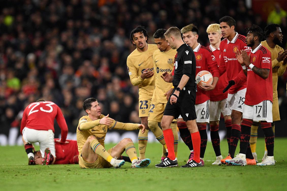 Barcelona’s Polish forward Robert Lewandowski reacts after colliding with Manchester United’s Brazilian midfielder Casemiro during their UEFA Europa league knockout round play-off second leg match at Old Trafford stadium in Manchester, on Feb. 23, 2023. (AFP)