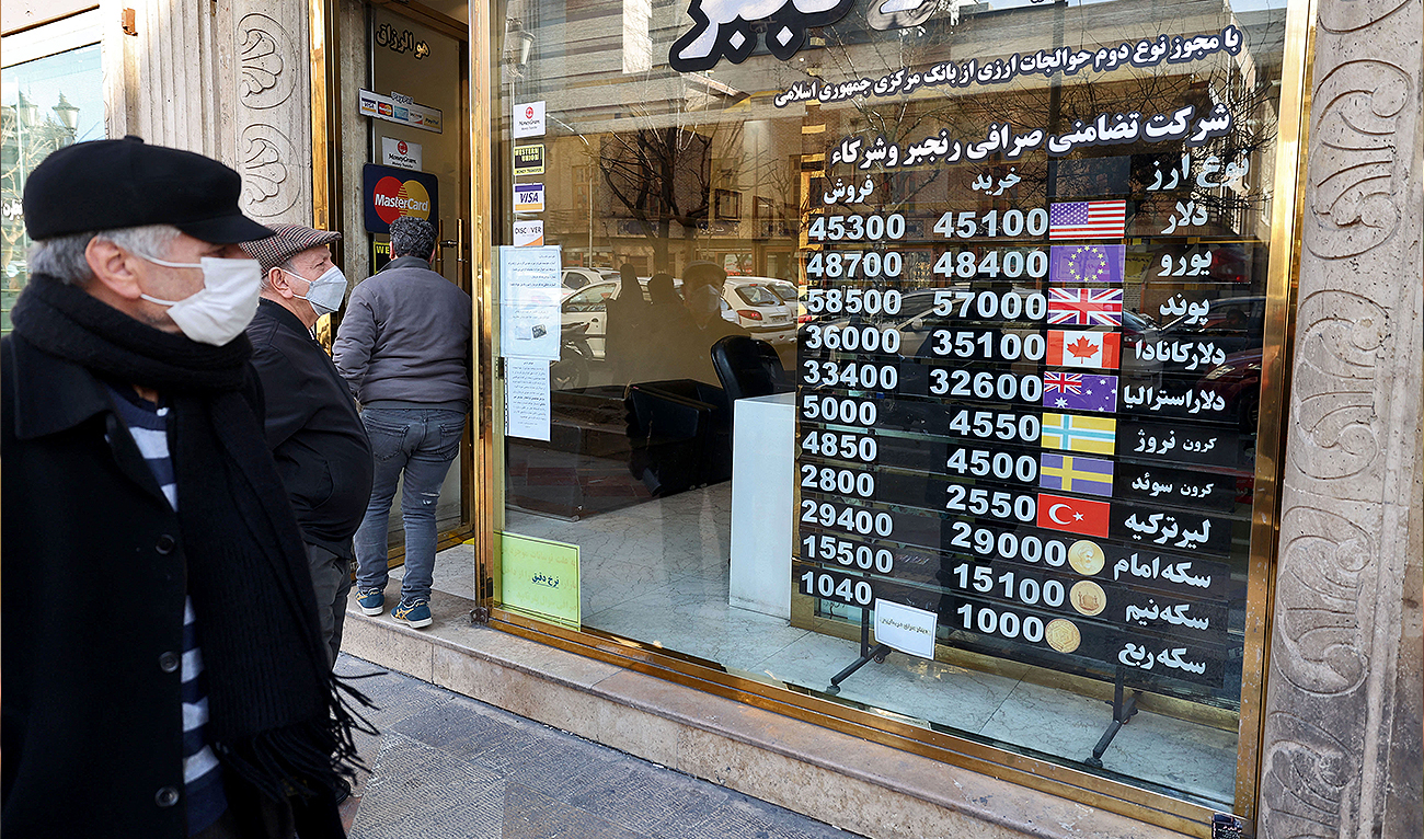 Men look at currency exchange rates at an exchange shop in Tehran on February 21, 2023. (Photo courtesy: AFP)